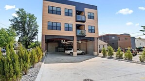 A multi-story building with a modern design, featuring a parking garage and a covered entrance. - King Bed + Sofa I Walk DT + Front St (Traverse City)