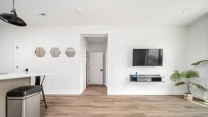 Eine moderne Küche mit weißer Arbeitsplatte, einem Mülleimer und einer Deckenleuchte.