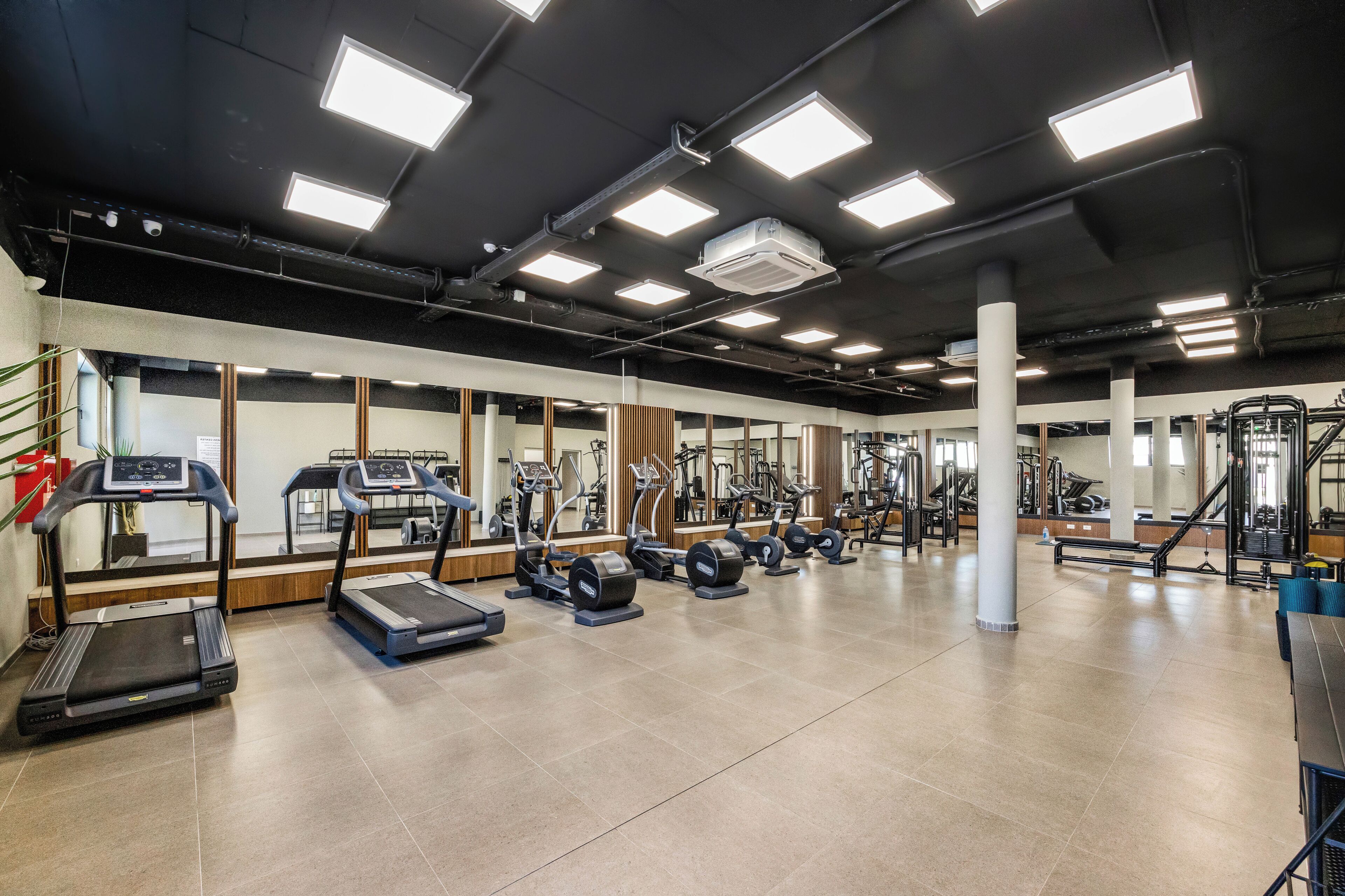 A gym with treadmills, elliptical machines, and weight equipment.