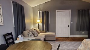 A compact living space with a sofa, a dining table, and a door. - Quiet, country space close to Oxford (Oxford)