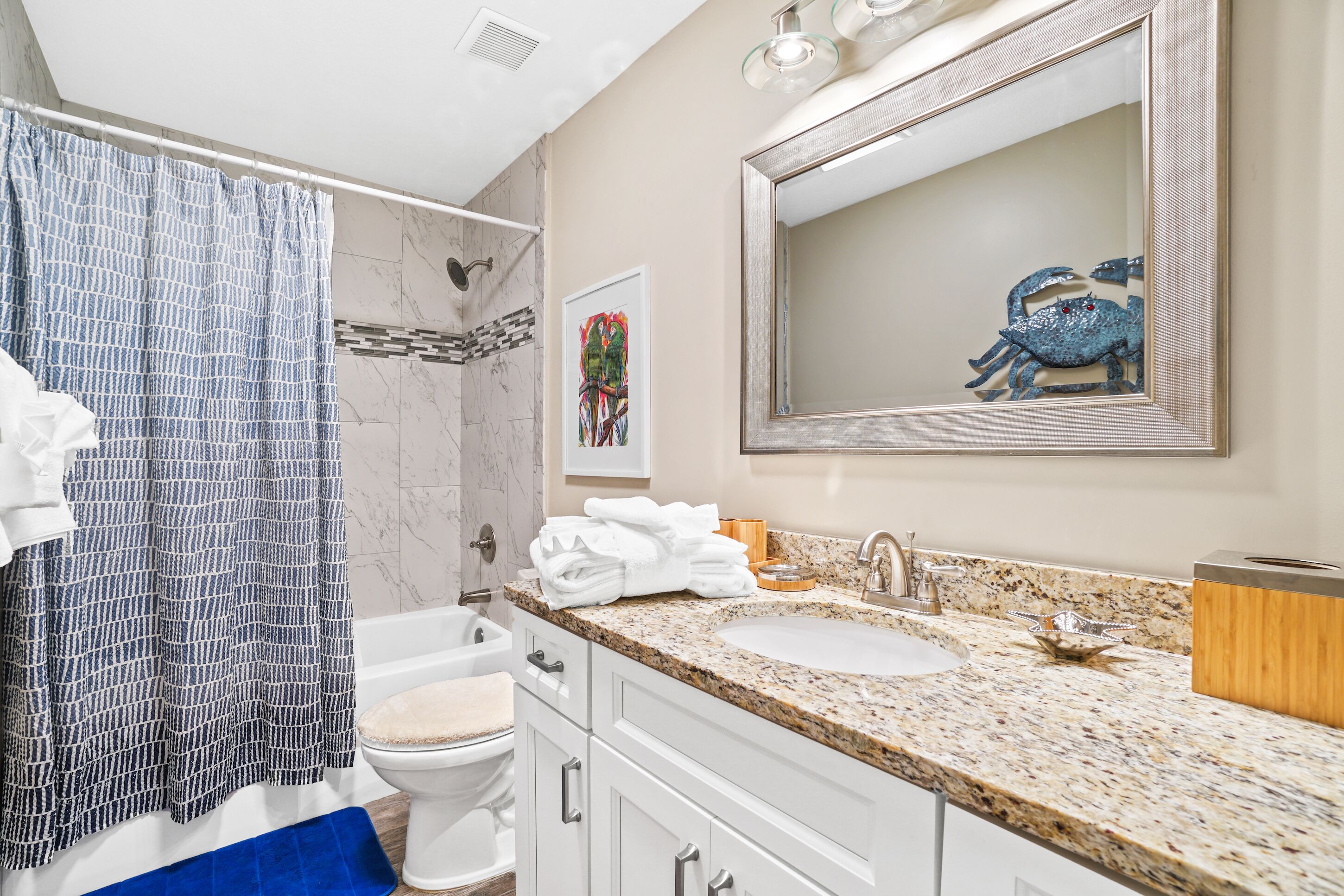 A bathroom with a shower, toilet, sink, and vanity.