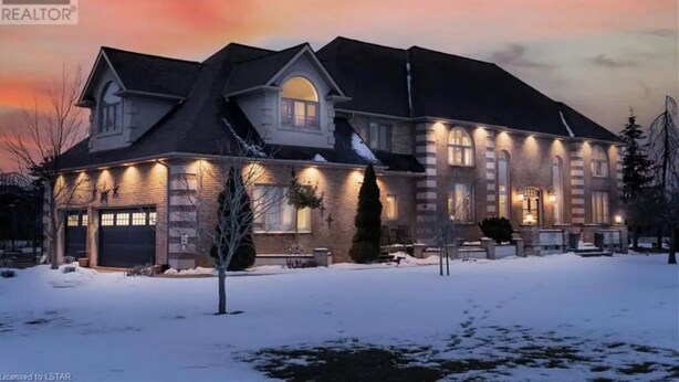 A large, two-story house with a brick exterior and multiple windows, surrounded by snow. - Luxury Villa next to golf course (LaSalle)