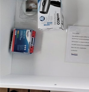 A white table with a first aid kit, a box labeled 'CONAIR,' and a price tag of $1.35.