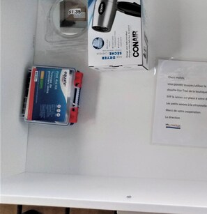 Un tavolo bianco con un kit di pronto soccorso, una scatola con l'etichetta 'CONAIR' e un cartellino del prezzo di 1,35 dollari.