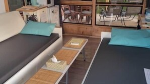 Une chambre moderne avec un canapé, une table et une fenêtre donnant sur du mobilier d’extérieur.