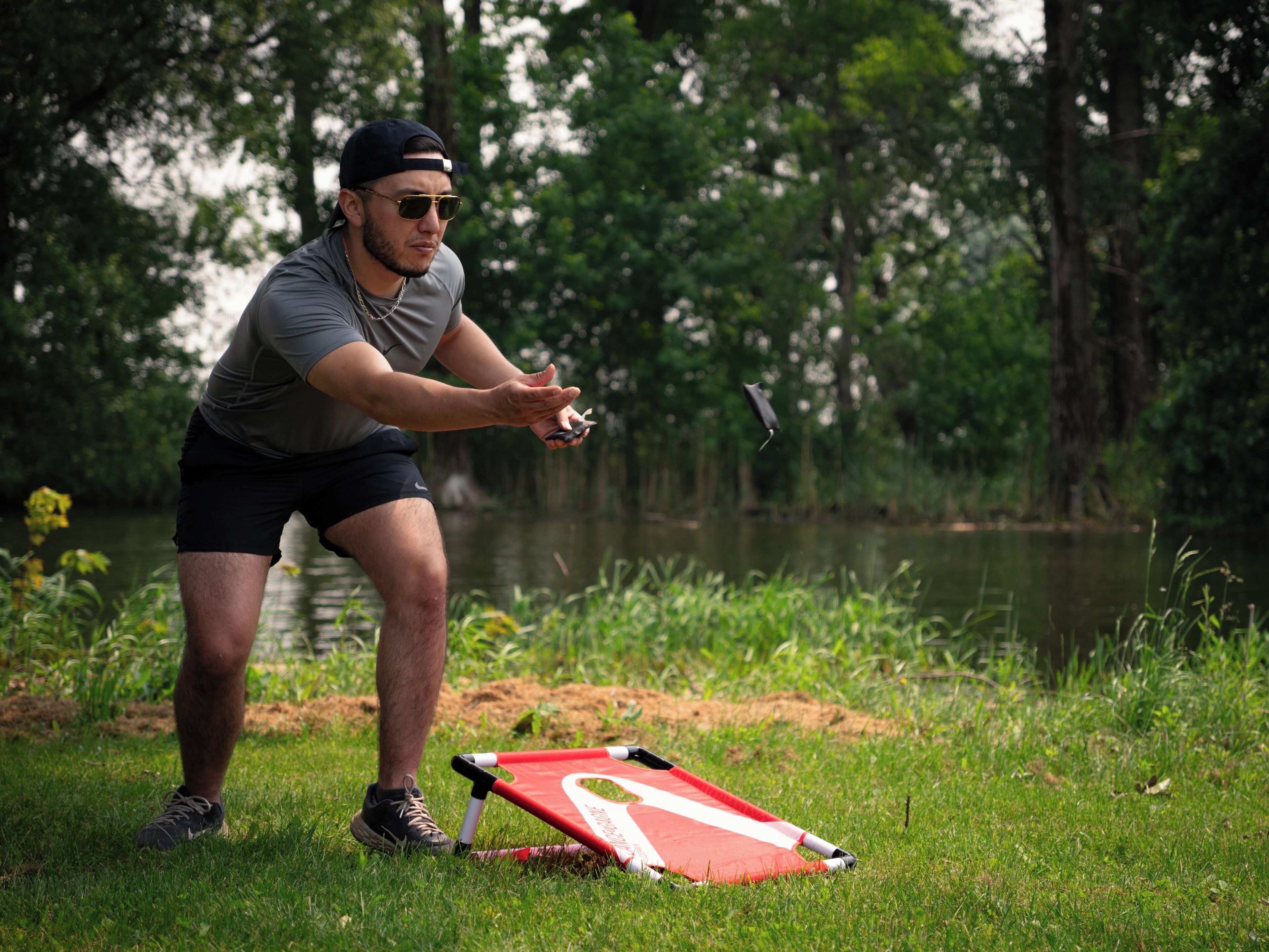 A person in a field with a red and white object on the ground.