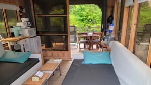 A cozy room with a bed, a small table, a chair, and a window overlooking greenery. - Aloberge 3 (Lacolle)