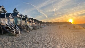A beach with wooden walkways leading to beach huts.