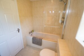 Ein Badezimmer mit Badewanne, Toilette und Dusche.