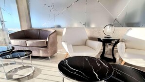 Un salon moderne avec un canapé, des fauteuils et une table basse.
