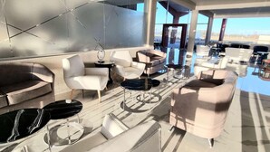 Un intérieur moderne avec un canapé, des fauteuils, une table basse et un téléviseur.
