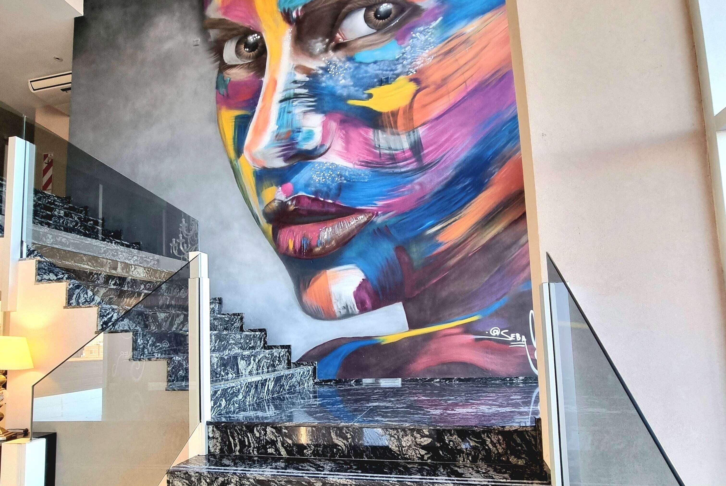 Una escalera con un gran mural en la pared.