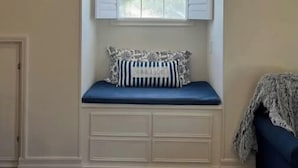 A bay window with a view of trees, a blue cushioned bench, and a patterned pillow. - Sunsets & Shows! Gorgeous, Private 1 BR Listing! (Mesa)