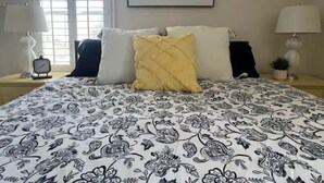 A bedroom with a bed, pillows, a wall clock, a framed quote, and a window with blinds. - Sunsets & Shows! Gorgeous, Private 1 BR Listing! (Mesa)