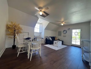 Relax in this inviting living area with a dining table, comfortable seating, and a potted plant.