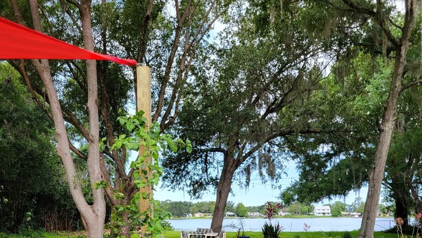 Un jardín con un camino empedrado que lleva a una zona de estar junto a un lago.