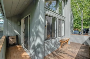 Enjoy a peaceful retreat on this serene property with a covered porch and comfortable seating area.