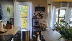Una cocina moderna con barra para café, un ventanal grande y un tapete amarillo estampado.