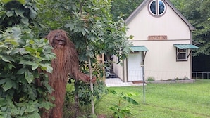 A rustic building labeled "BIGFOOT INN" with a small porch and a circular window. - Bigfoot Inn -cabin with loft -near Illinois River (Tahlequah)