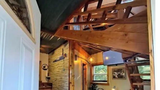 A cozy interior with a wooden staircase, a dining area, and a kitchen. - Bigfoot Inn -cabin with loft -near Illinois River (Tahlequah)