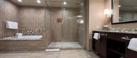 A modern bathroom with a glass-enclosed shower, a freestanding bathtub, and a vanity with a mirror.