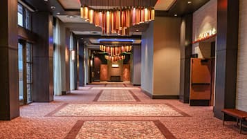 Un pasillo de hotel con indicaciones hacia el balcón, salones de baile y los baños.