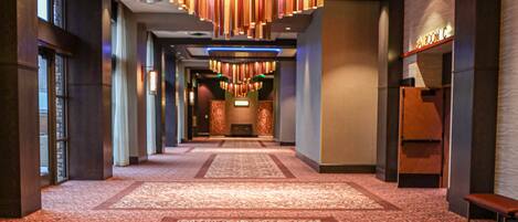 A hotel corridor with directional signs to the balcony, ballrooms, and restrooms.