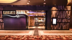 Entrada moderna do Kankakee Grille, com padrão de piso xadrez e um painel de parede de madeira.