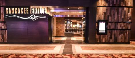 Una entrada moderna al Kankakee Grille, con un piso de patrón a cuadros y un fondo de pared de madera.