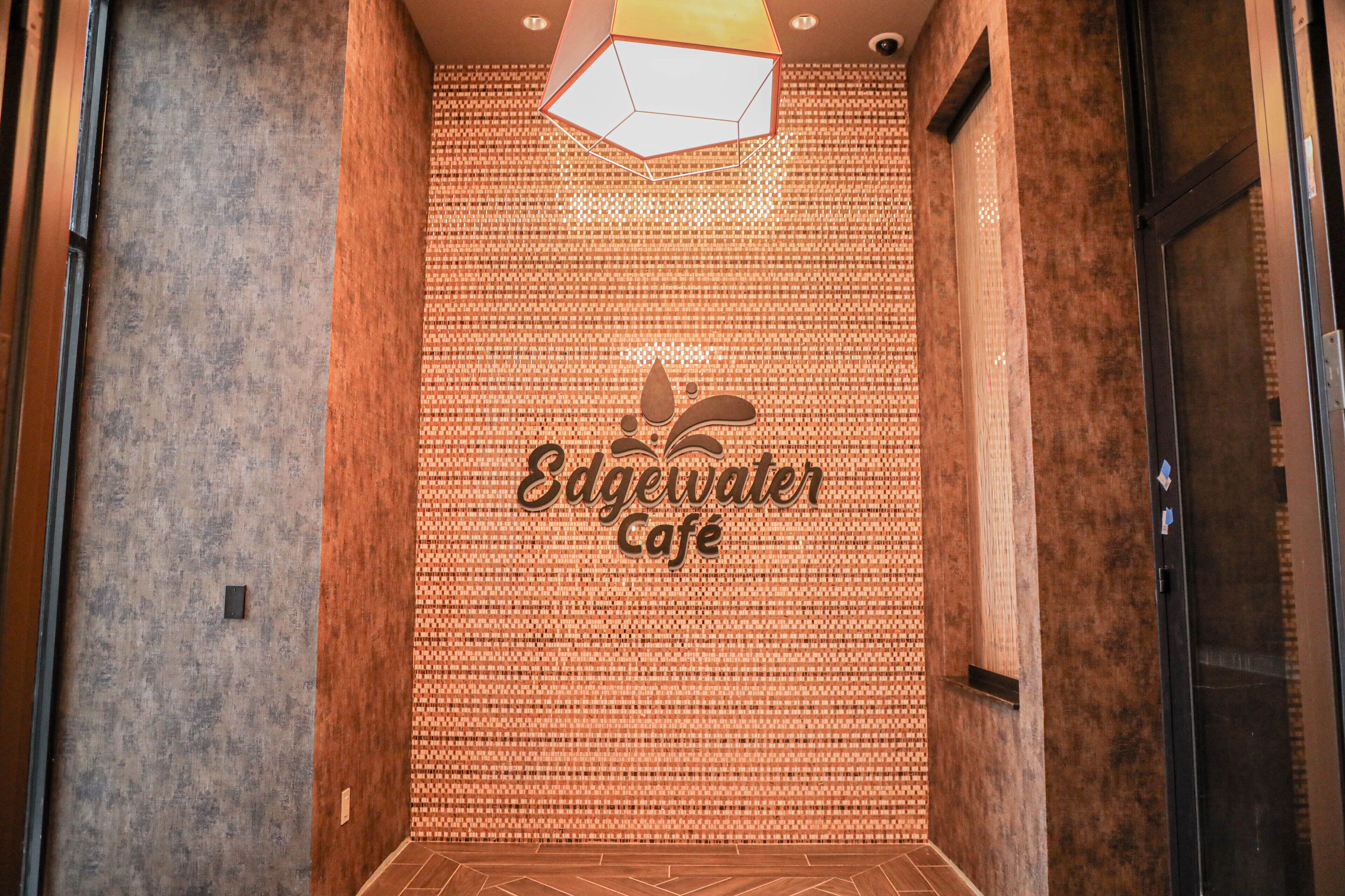 Un couloir avec un mur à texture et une enseigne indiquant « Edgewater Café ».