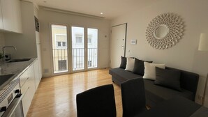 A modern apartment with a kitchen, dining area, and a living room with a sofa and chairs. - Gorgeous 1 BDR (sleeps 4) w/ Ocean View 2 min from the beach (Nazaré)