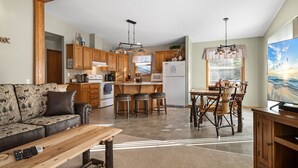 A spacious living area with a sofa, a wooden coffee table, and a TV on a wooden stand. - Cozy Lake Alice Cottage Next to Trails & WI River! Pet Friendly! (Tomahawk)