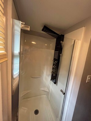 Chuveiro, secador de cabelo, toalhas de banho, papel higiênico