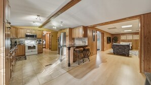 Eine geräumige Küche mit Holzschränken, einer Kochinsel und einem Essbereich mit einer Couch und Stühlen.