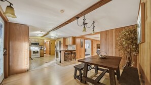 Eine geräumige Küche mit Holzausstattung, einer zentralen Kochinsel und einem Essbereich mit Holztisch und Bänken.