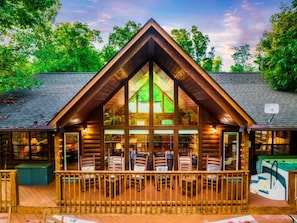 Relax in this cozy cabin surrounded by trees, with a spacious outdoor seating area and large windows for a peaceful atmosphere.