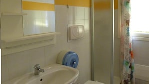 A bathroom with a sink, mirror, and shower. - Ostello Torino (Turin)
