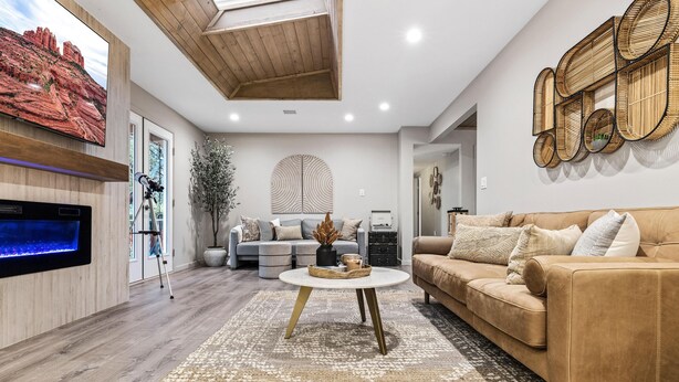 Una sala de estar moderna con televisor de pantalla plana, chimenea, sofá y una mesa de centro.