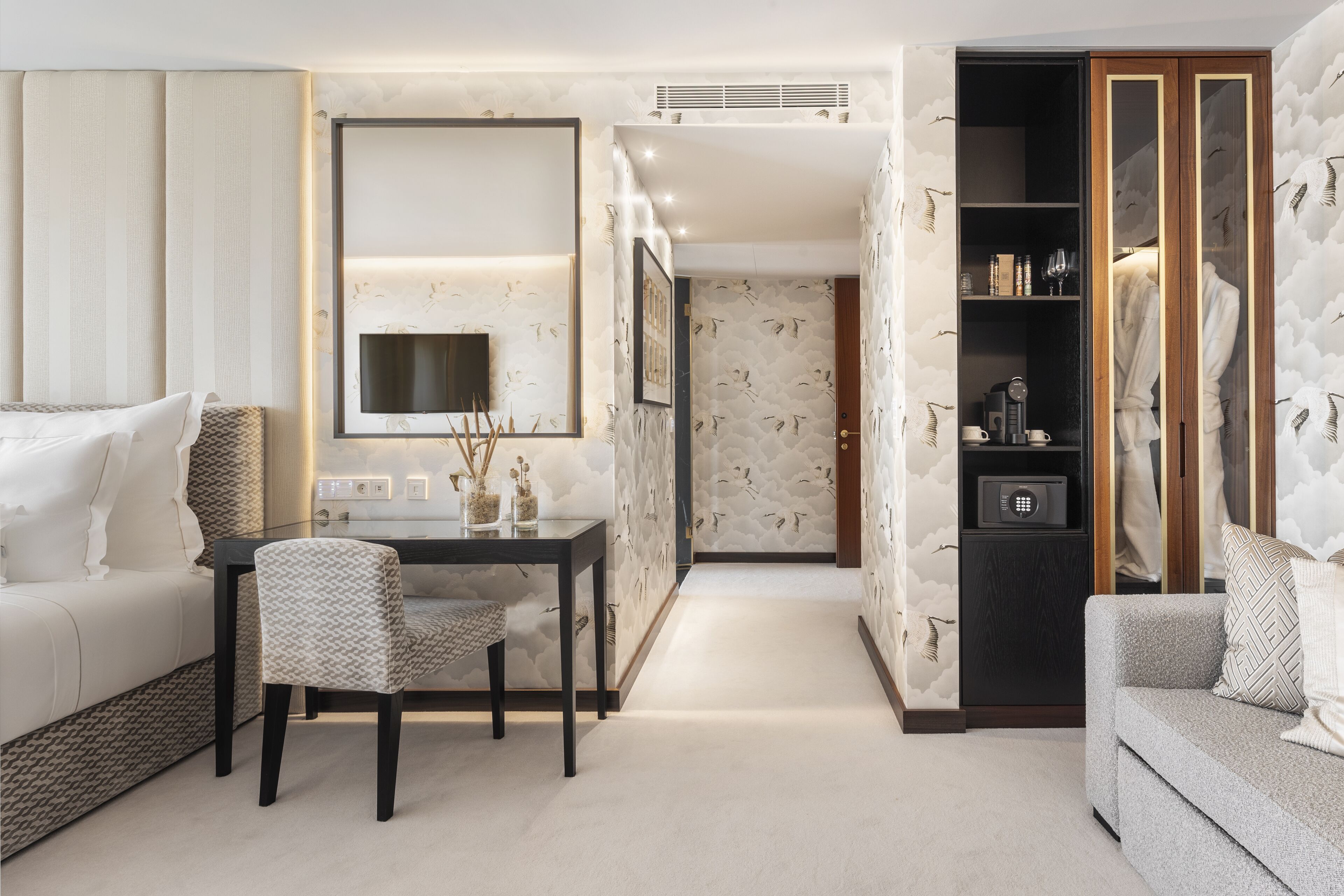 A modern living room with a sofa, a dining table with chairs, a TV, and a wardrobe.