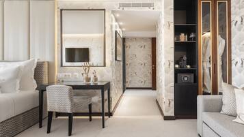 A modern living room with a sofa, a dining table with chairs, a TV, and a wardrobe.