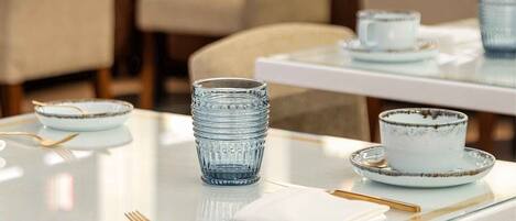 A restaurant with tables set for dining, featuring glassware and plates.