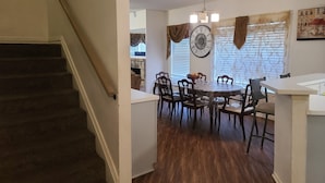 A dining area with a round table, chairs, a clock, and a window with blinds. - House of Comfort, A centrally located 4 bedroom home. (Duncanville)