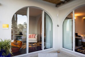 Ein modernes Interieur mit einer Couch, einer Glastür und einer Pflanze.