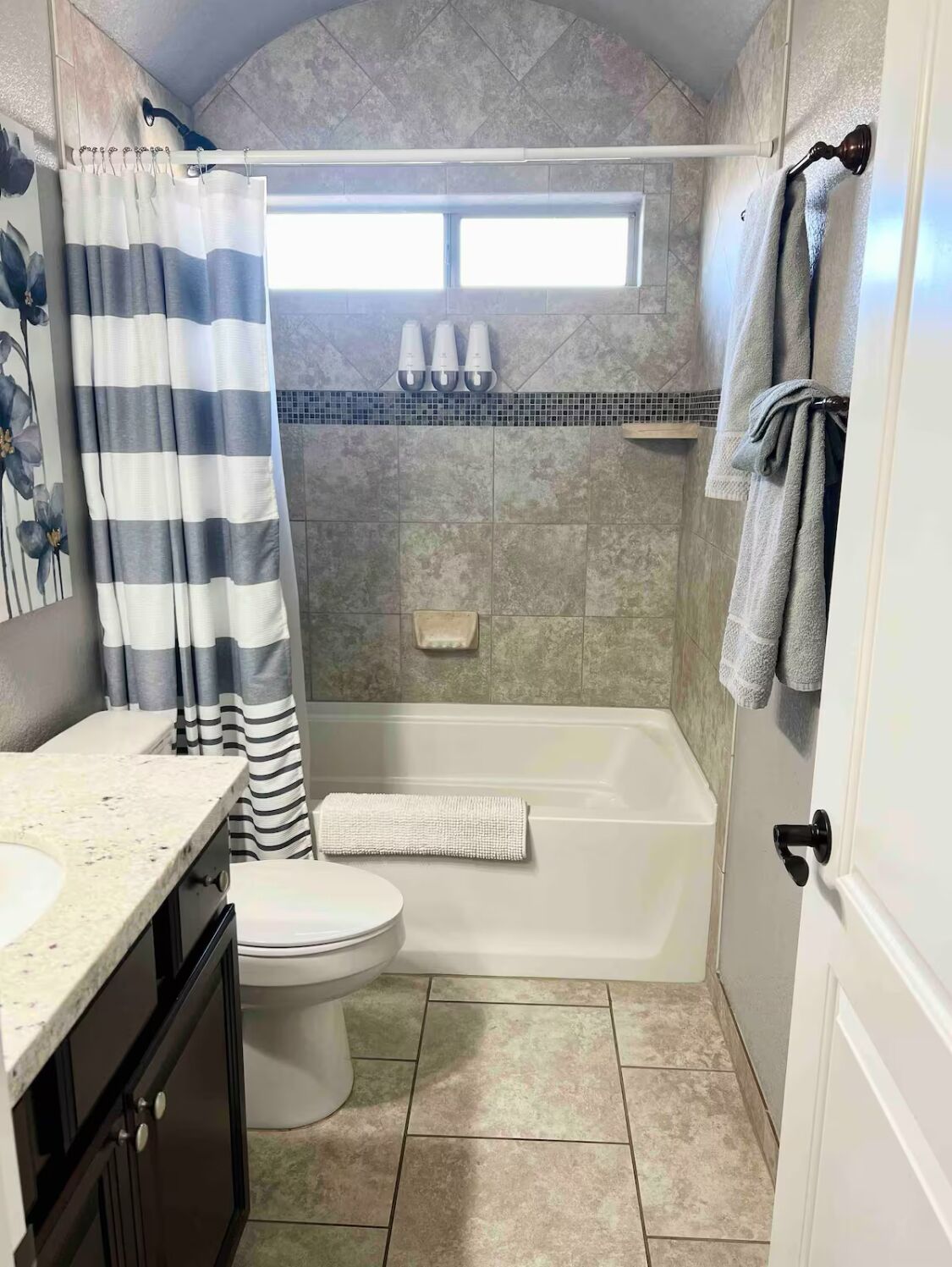 A bathroom with a shower, toilet, and sink.
