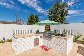 An outdoor barbecue area with a brick wall, grill, and seating. - ARCADIA NEW BUILD-5 BED/4.5 BATH-PRIME LOCATION (Phoenix)