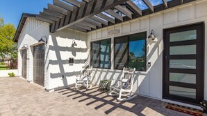 Una casa con patio coperto, garage e porta d'ingresso con tappeto di benvenuto.
