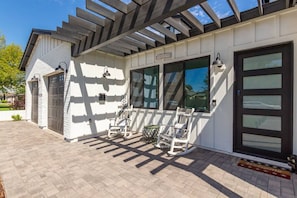 A house with a covered patio, a garage, and a front door with a welcome mat. - ARCADIA NEW BUILD-5 BED/4.5 BATH-PRIME LOCATION (Phoenix)