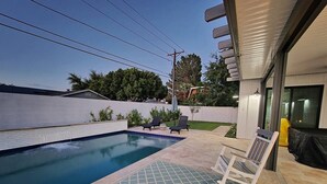Una piscina con lettini da spiaggia e un tappeto decorato.