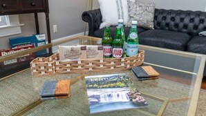 A glass coffee table with a woven basket containing bottles of beer and a book titled "Kentucky". - The Colonels Apartment is a freshly renovated 3bedroom 1bath downtown Richmond apartment (Richmond)