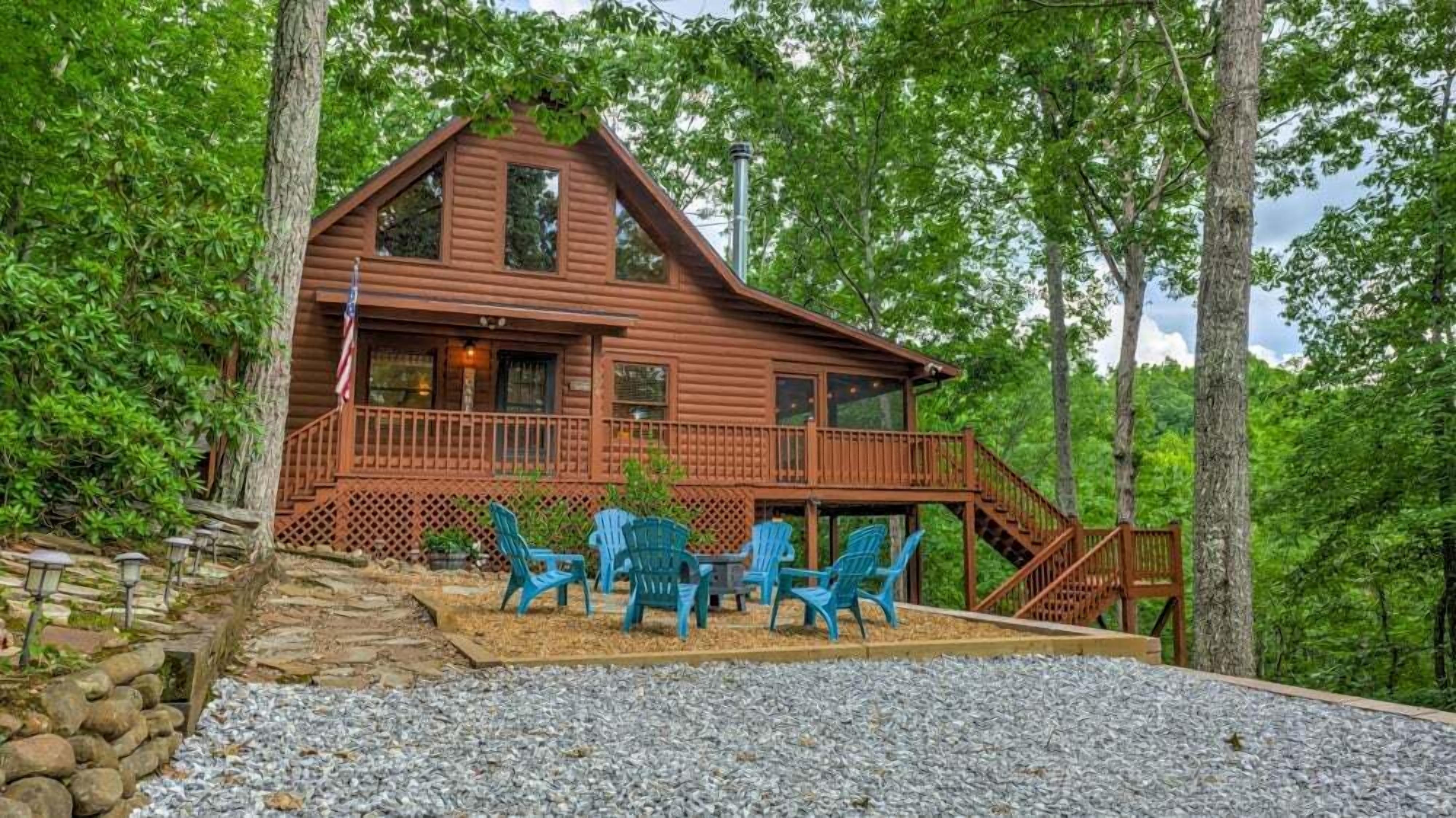 Une cabane en bois avec un porche, des sièges d’extérieur et un drapeau.